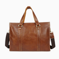 Brown leather briefcase with shoulder strap on a white background