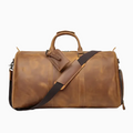Brown leather duffel bag with a shoulder strap on a white background